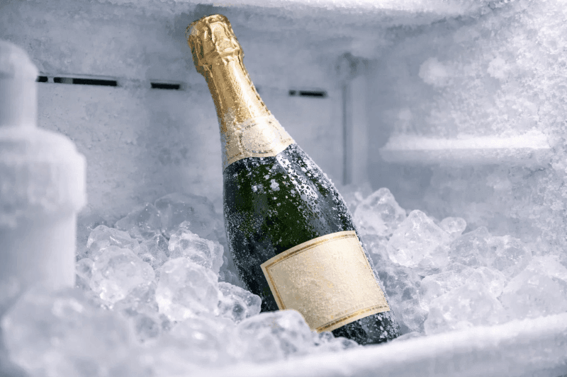 https://www.californiachampagnesabers.com/wp-content/uploads/2025/03/Champagne-bottle-chilling-in-an-icy-freezer-surrounded-by-frost-and-ice-cubes.png