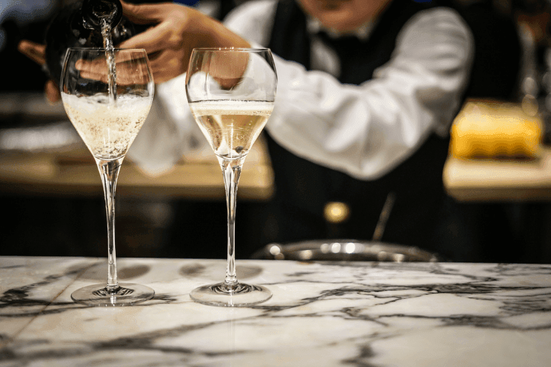 https://www.californiachampagnesabers.com/wp-content/uploads/2026/02/Bartender-pouring-chilled-Spumante-on-marble-counter.png