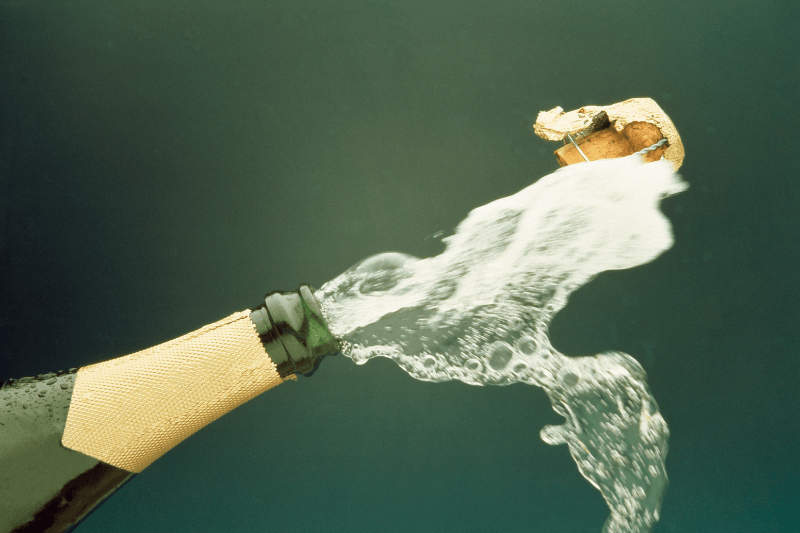 https://www.californiachampagnesabers.com/wp-content/uploads/2026/05/Champagne-bottle-popping-with-cork-flying-and-bubbles-spraying.png